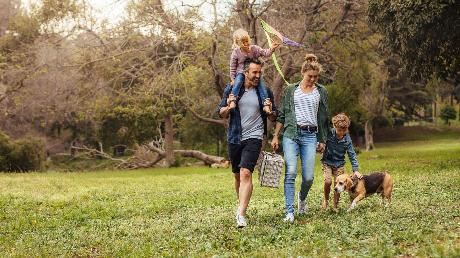 Family with dog walking in park 16:9